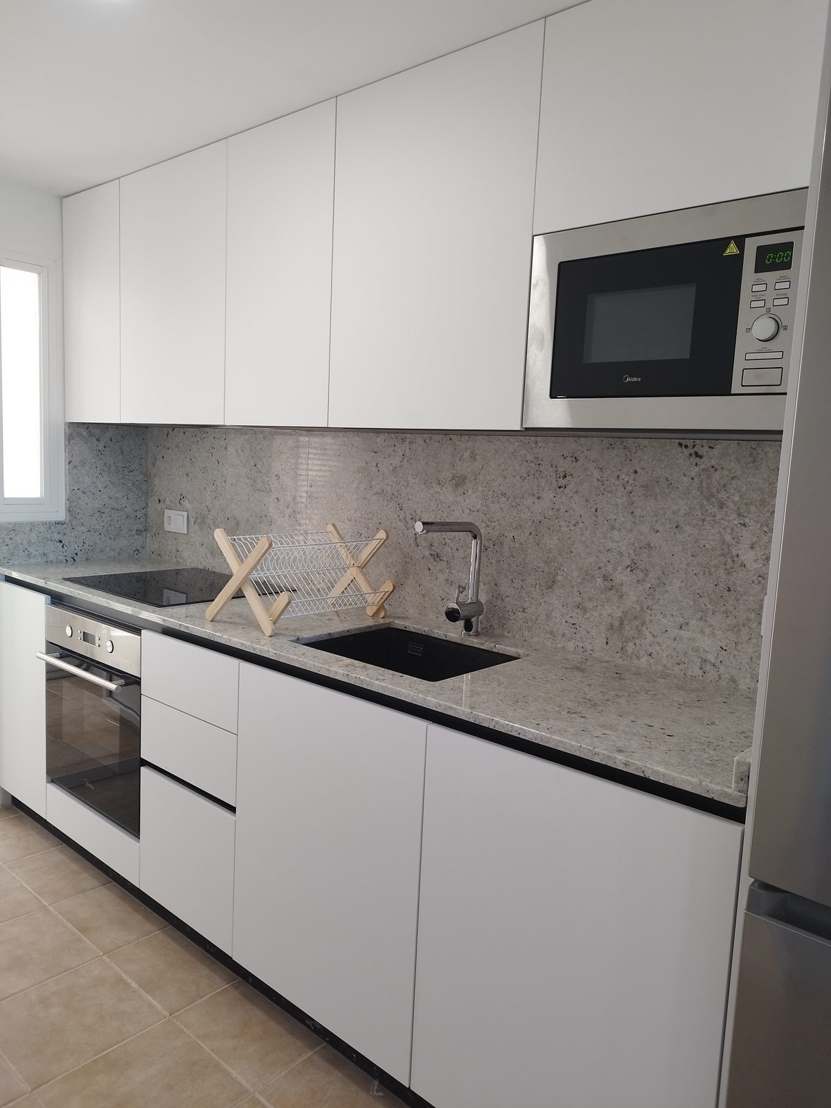 Cocina montada con muebles y encimera de granito