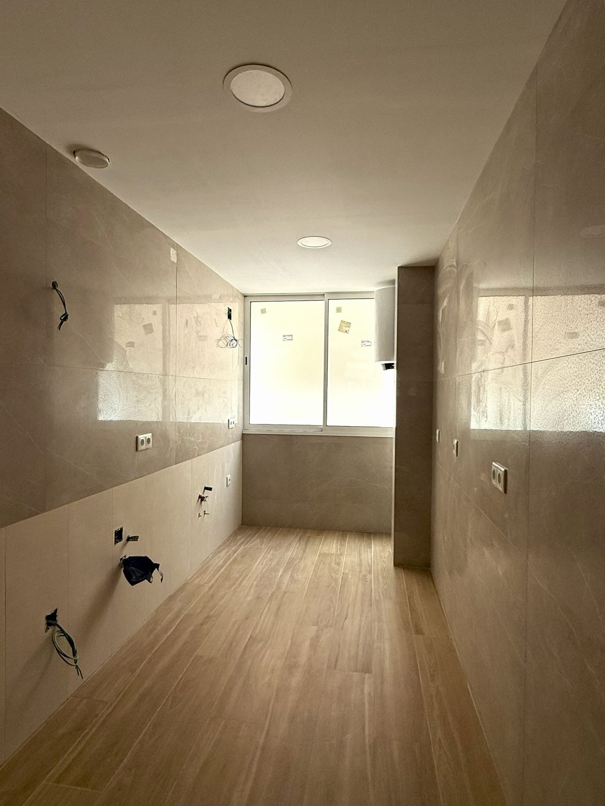 Baño terminado con alicatado y ventana